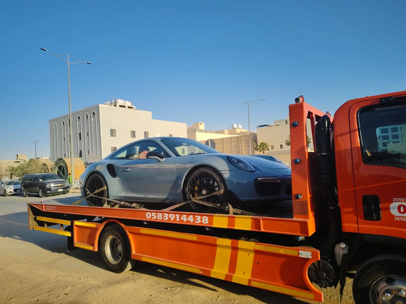 سطحة برتقالية تنقل بورش 911 رمادية في الخبر