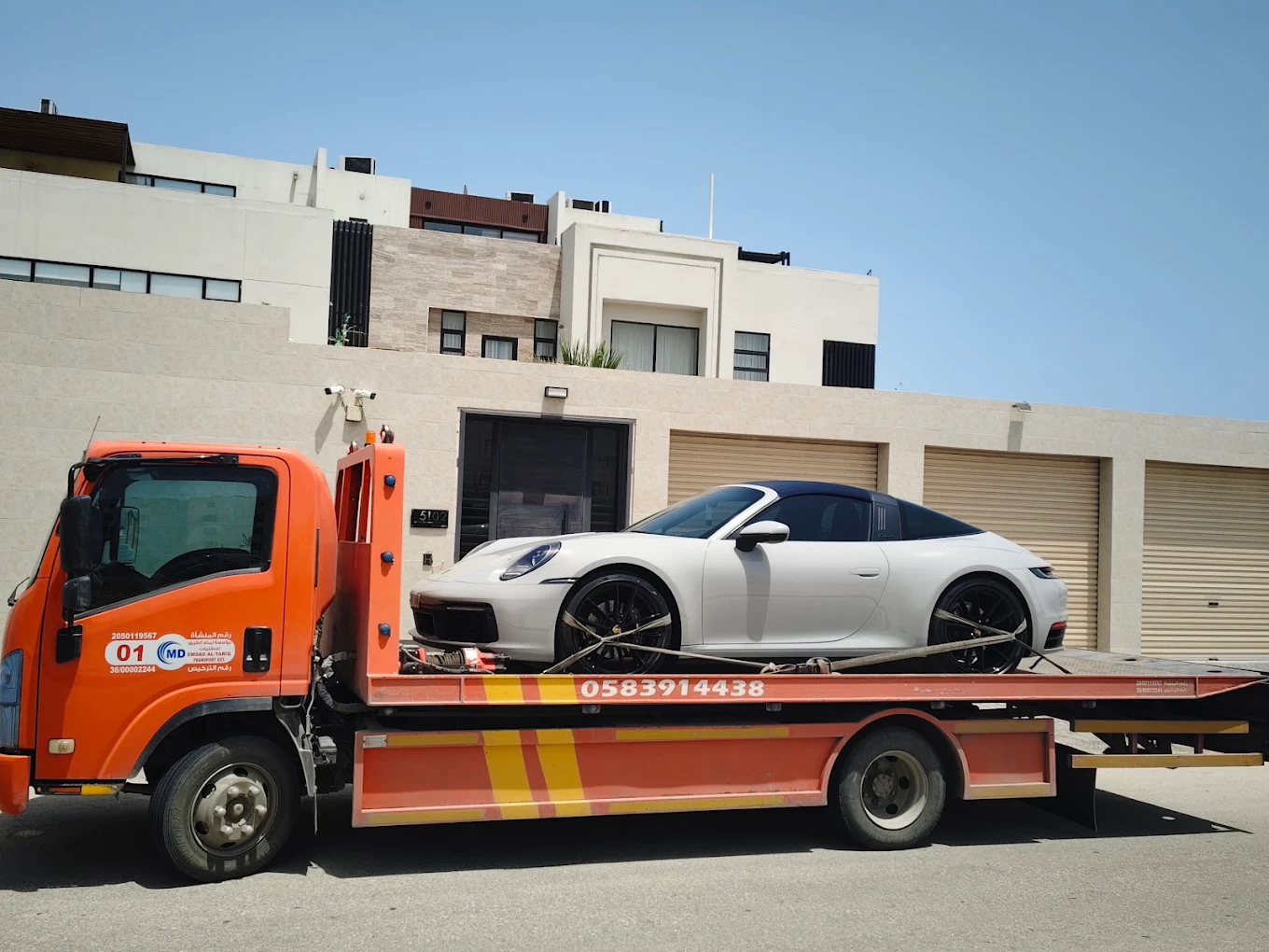 سطحة هيدروليك تنقل بورش 911 تارجا بيضاء أمام فيلا